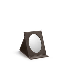 A small oval foldable mirror with a brown leatherette frame, positioned upright.