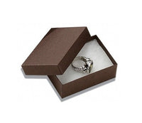 An open chocolate kraft paper cotton filled box with a piece of jewelry displayed inside