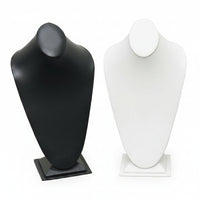 Two necklace displays, one in black and one in white, both with a tall, mannequin-like neck portion, set on a flat base.