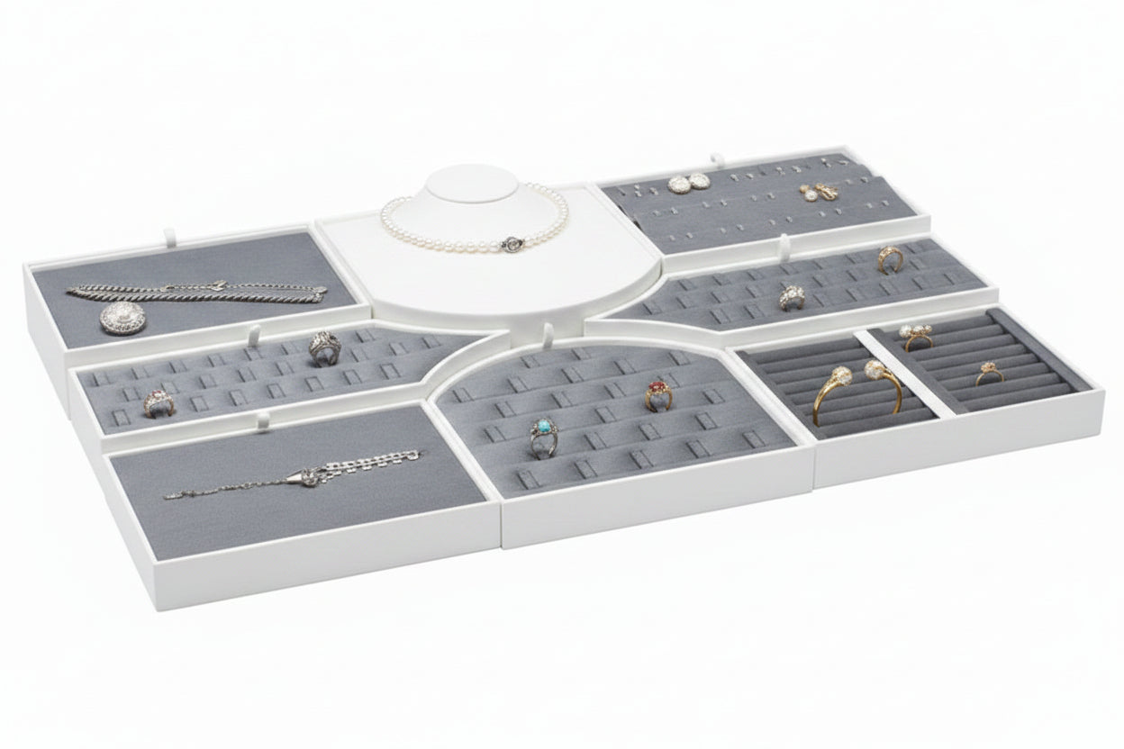 White jewelry display tray with various jewelry items on a white background