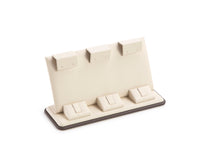 A chocolate and beige leatherette earring/ring stand with three slots for displaying jewelry items.