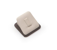 A chocolate and beige leatherette ring display clip with a soft, cushioned surface.