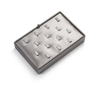 A silver gray leatherette jewelry display ring holder with multiple individual ring compartments.