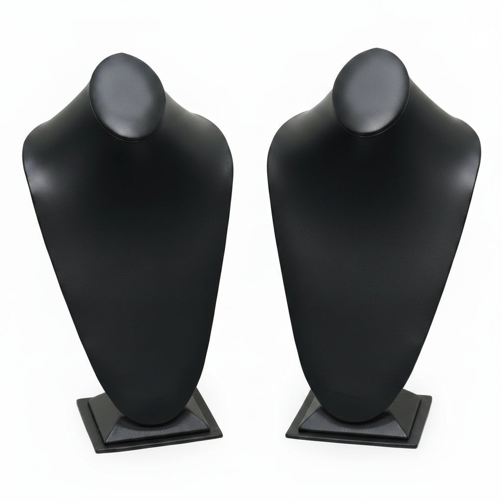 Black and white mannequin busts on stands against a white background