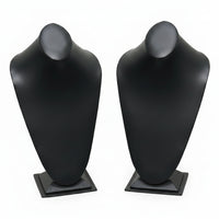 Black and white mannequin busts on stands against a white background
