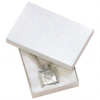 A white cotton filled jewelry box with a swirl pattern, presented with a silver necklace inside.
