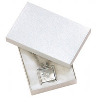 A white cotton filled jewelry box with a swirl pattern, presented with a silver necklace inside.