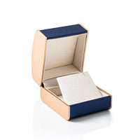 Open jewelry box with blue interior and beige lining on a white background