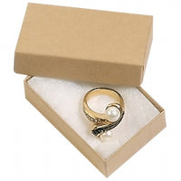 A kraft paper cotton filled box opened to reveal a small piece of jewelry inside.