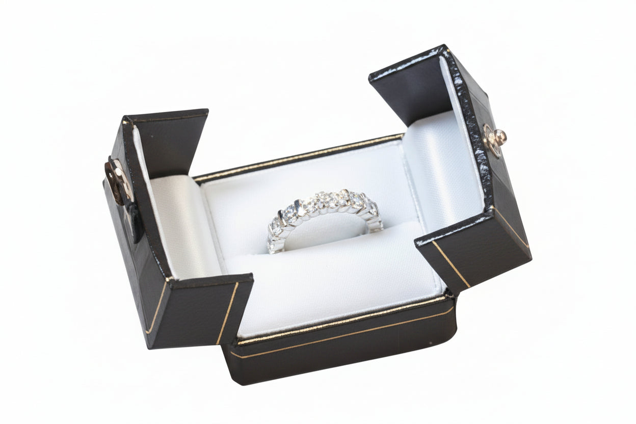 Silver ring in a brown jewelry box on a white background