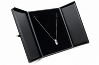 Necklace with a purple pendant in an open black jewelry box on a white background