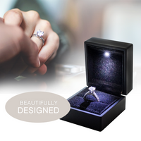 Black open jewelry box with a ring inside