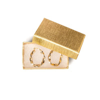 Gold hoop earrings in a decorative box 