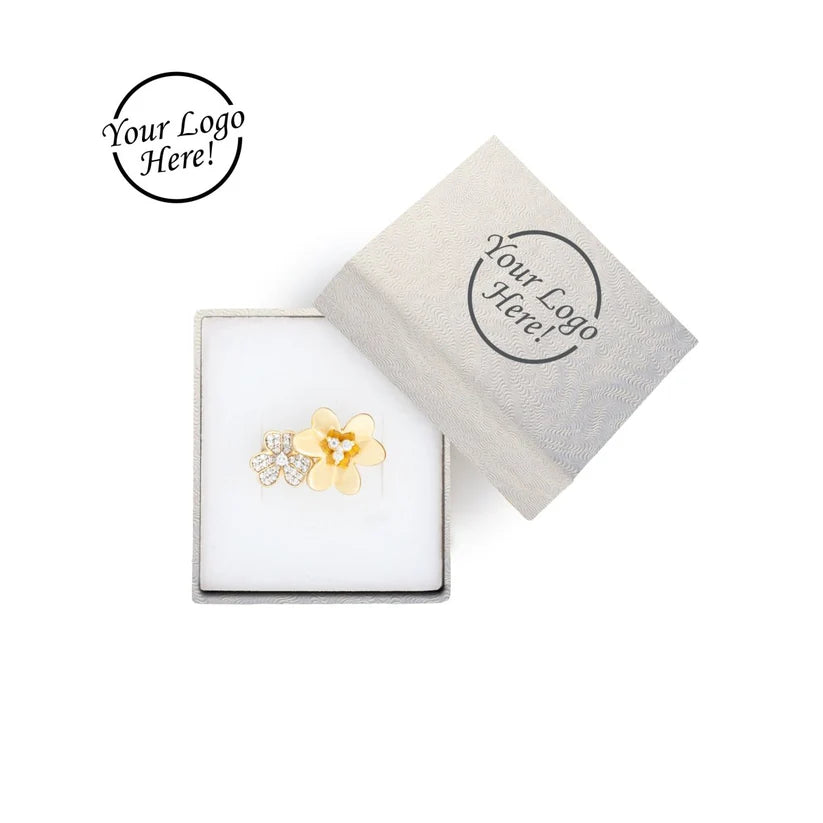 Flower-shaped earring in a white box with a branded label 