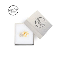 Flower-shaped earring in a white box with a branded label 