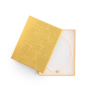 Gold necklace in an open yellow jewelry box 