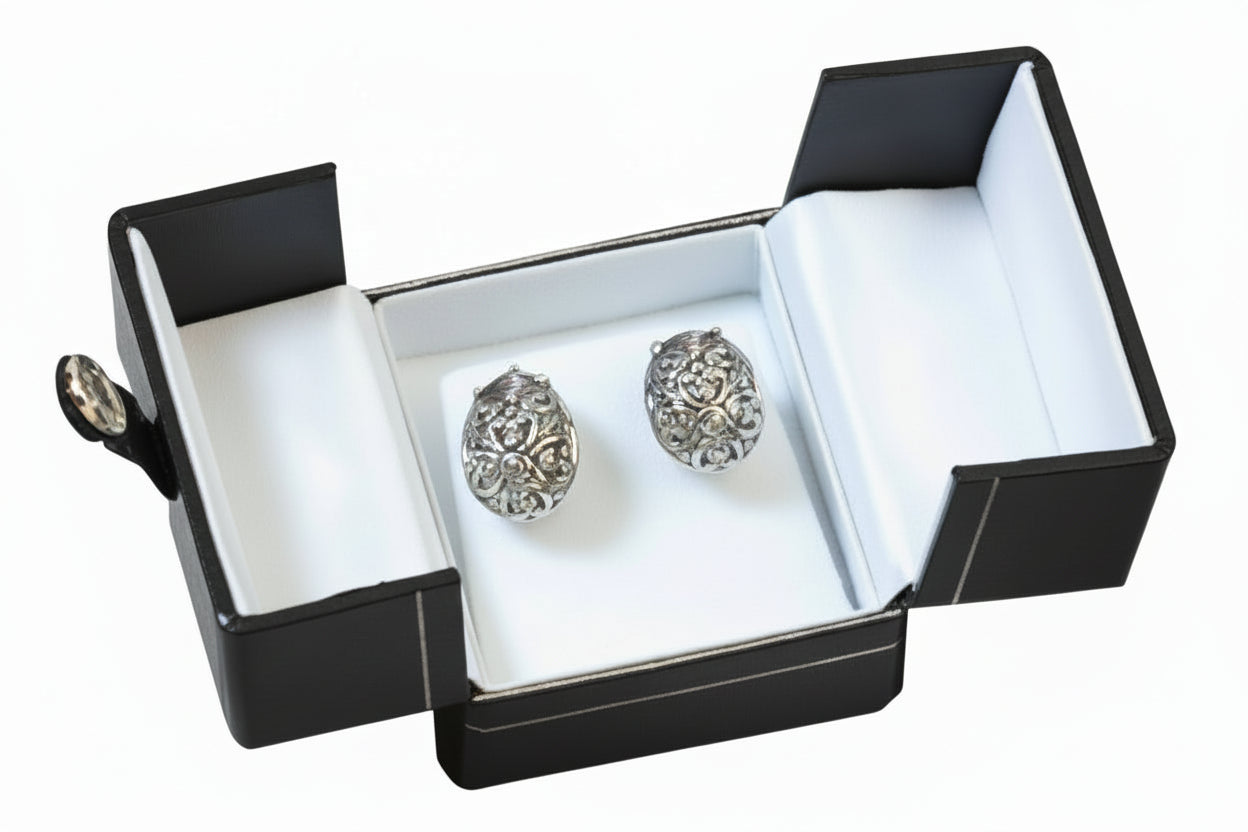Silver earrings in an open black jewelry box 