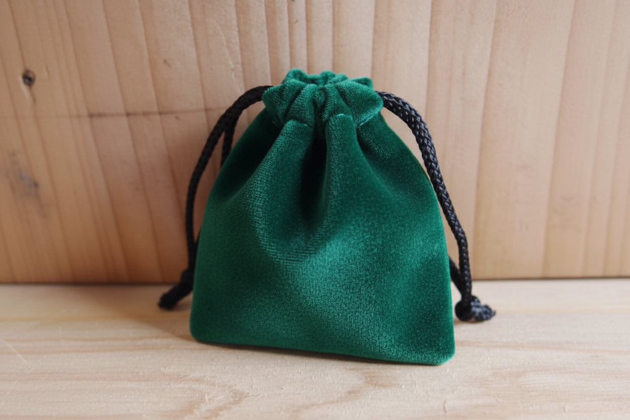 green drawstring pouch on a wooden surface
