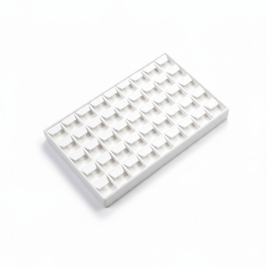 White jewelry display tray with multiple compartments on a white background