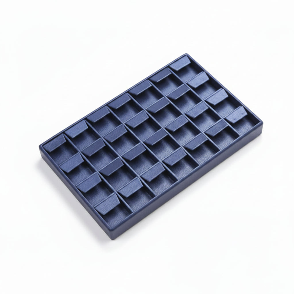 Navy blue leatherette earring tray designed to hold up to 28 pairs of earrings, with a soft interior lining.