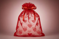 Three drawstring bags in white, pink, and red on a gray background