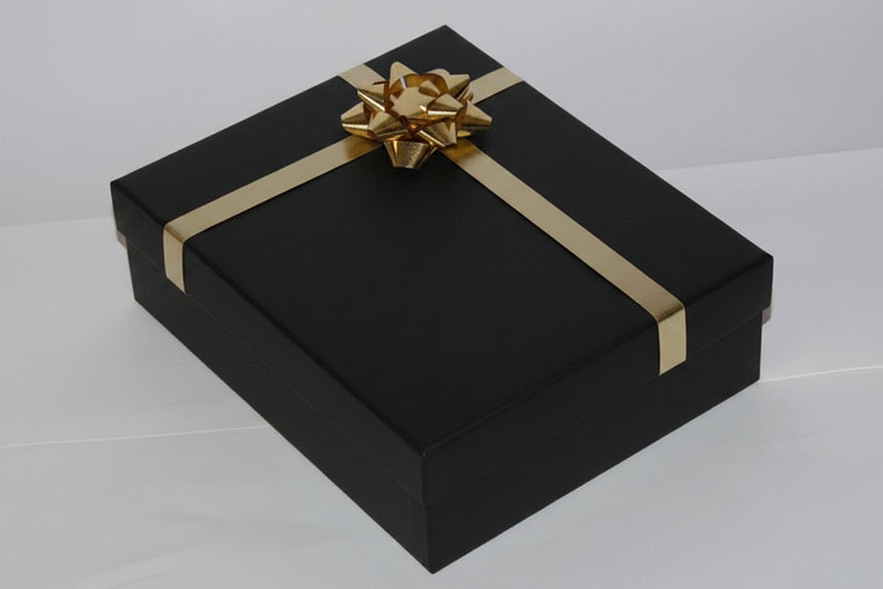 Black gift box with gold ribbon on a white background