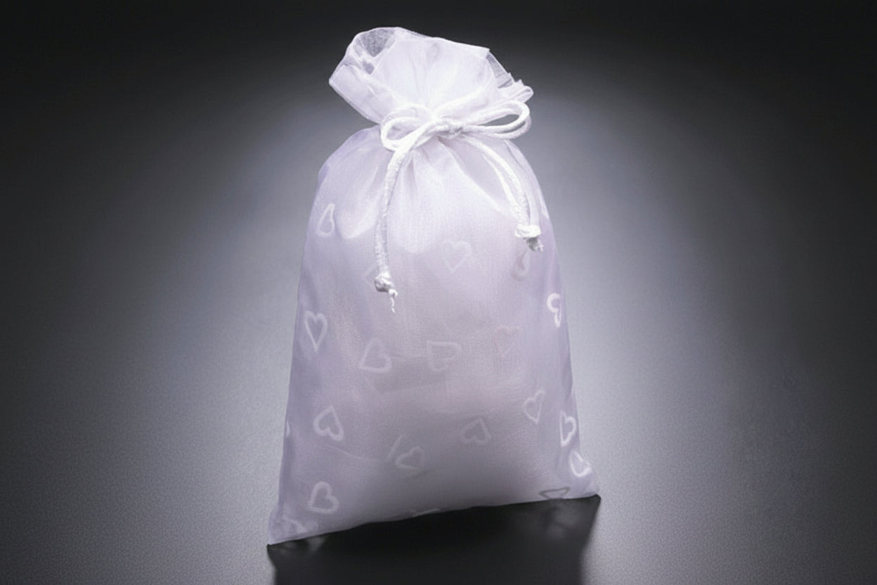 Three drawstring bags in white, pink, and red on a gray background