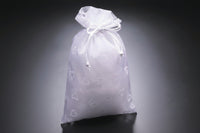 Three drawstring bags in white, pink, and red on a gray background